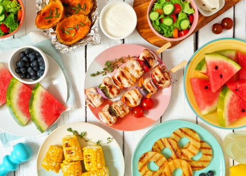 Summer Spread of watermelon, blueberries, salad, corn, grilled pineapple, chicken and vegetable skewers