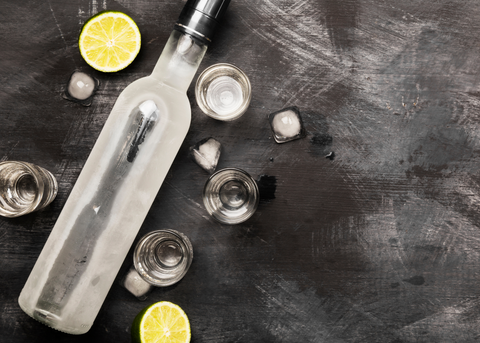 vodka bottle, multiple shot glass, lemon cut in half