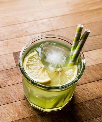 Midori Sour from upward shot with two straws and two lemon slices