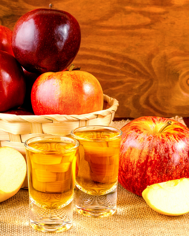 two Washington apple shots with apples in basket behind