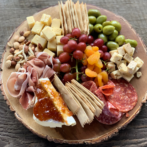 Charcuterie board with meats, cheeses, fruits, nuts, olives, crackers