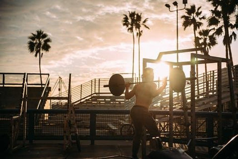 man squatting outside at beach