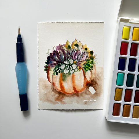 A watercolor succulent pumpkin with a watercolor pan and water brush