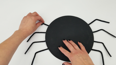 Black painted paper plate and chenille stems