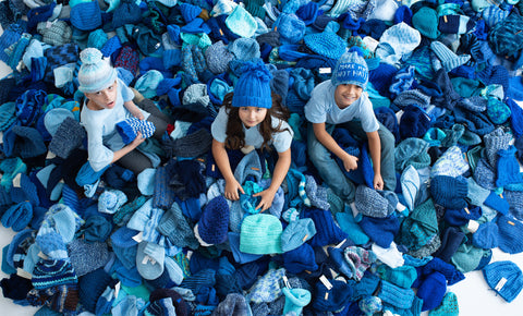 Children in a pile of blue hats