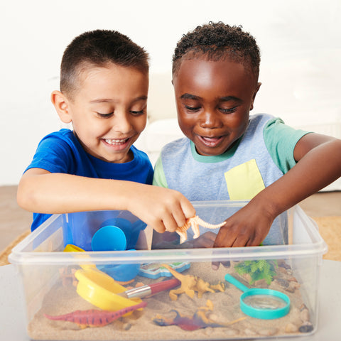 Two kids playing with a sensory bin