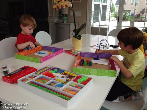 Two boys creating art at table