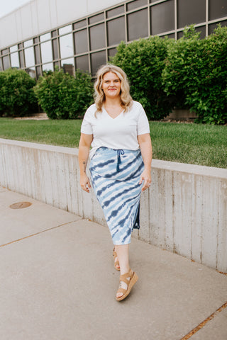 Plus size woman wears a tie dye skirt with a plain white tee