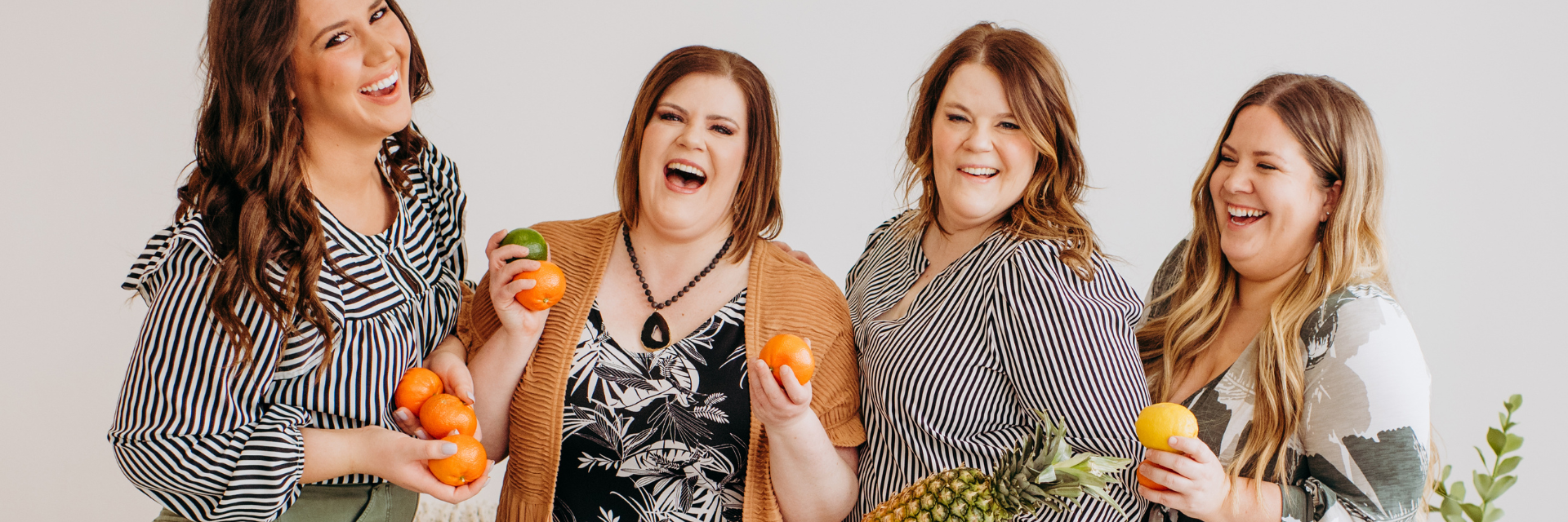 Women holding fruit and laughing