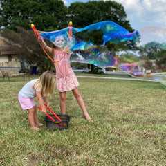Two girls blowing giant bubbles The Cottonseed Marketplace
