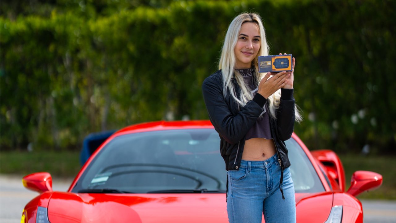 A woman holding Pedal Commander throttle response controller