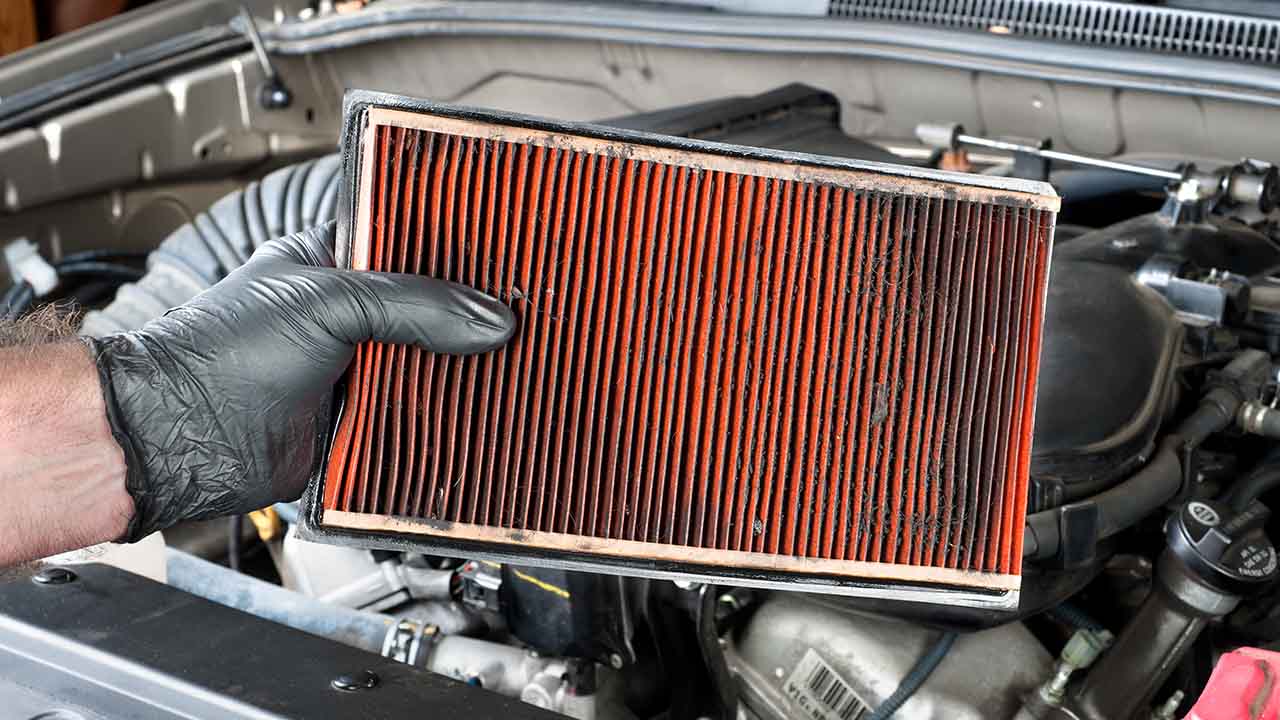 hand-holding-air-filter-over-car