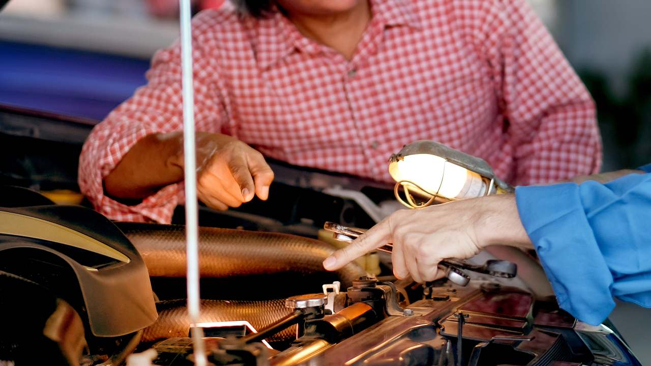 men checking car's engine life