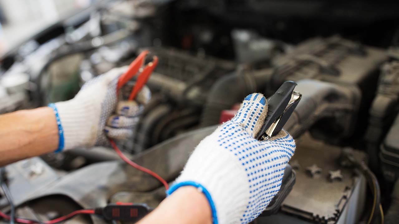 car-battery-jump-starting-cables-held-over-battery