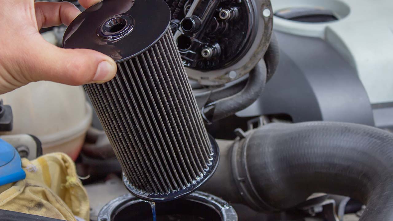 hand-removing-fuel-filter-from-car