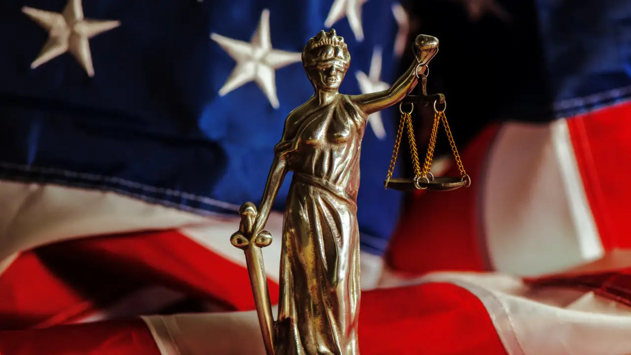 A justice statue in front of an USA flag