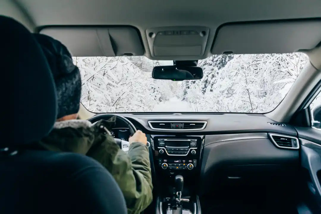 Man drives a car on snowy road