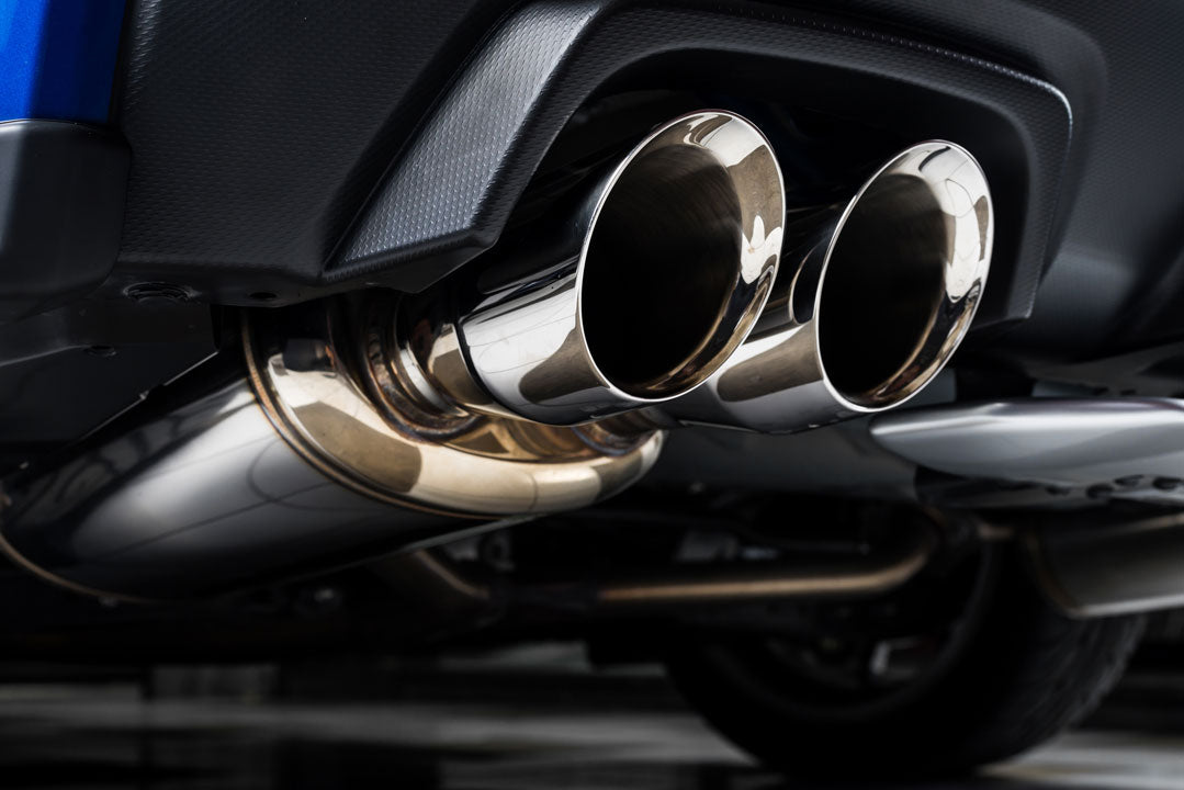 A photo of underside of a car with exhaust tips and exhaust muffler on the focus.