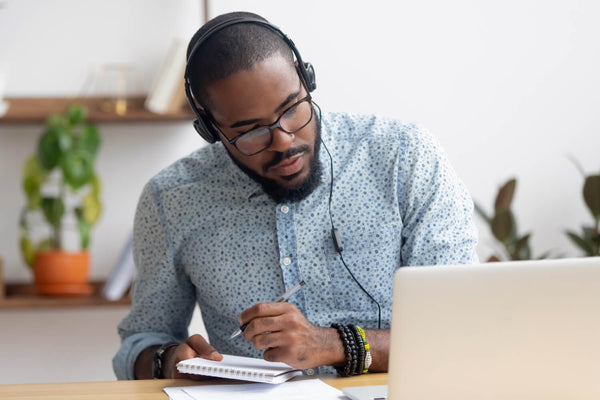 Man engaged in online learning, acquiring knowledge through focused study on a laptop