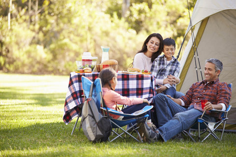 A picture of a family camping outdoors.