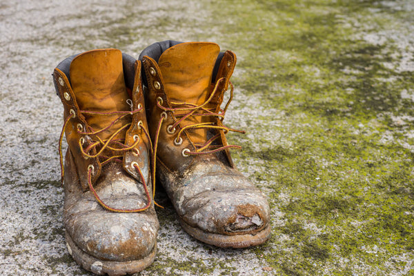 Worn and oversized safety shoes, showing their aged and bulky appearance.