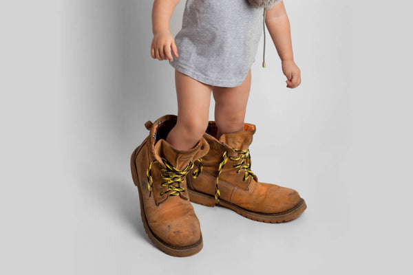 A child wearing oversized shoes.