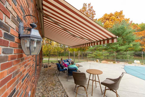 Home Awning Extended Over People Sitting Next to Pool