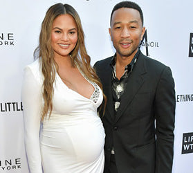 Chrissy Teigen in pregnant in white dress next to John Legend