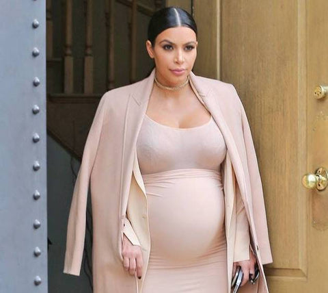 Pregnant Kim Kardashian in a blush pink dress and blazer
