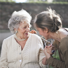 Elderly woman smiling next to a younger woman