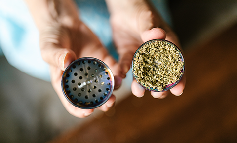 An illustration included in 'How to Use a Bong: A Step-by-Step Guide for Smoking Weed' by The DART Company, demonstrating the process of grinding cannabis with a grinder.