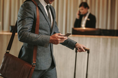 A man in a hotel with a smartphone - Brandstand battery saving tips.