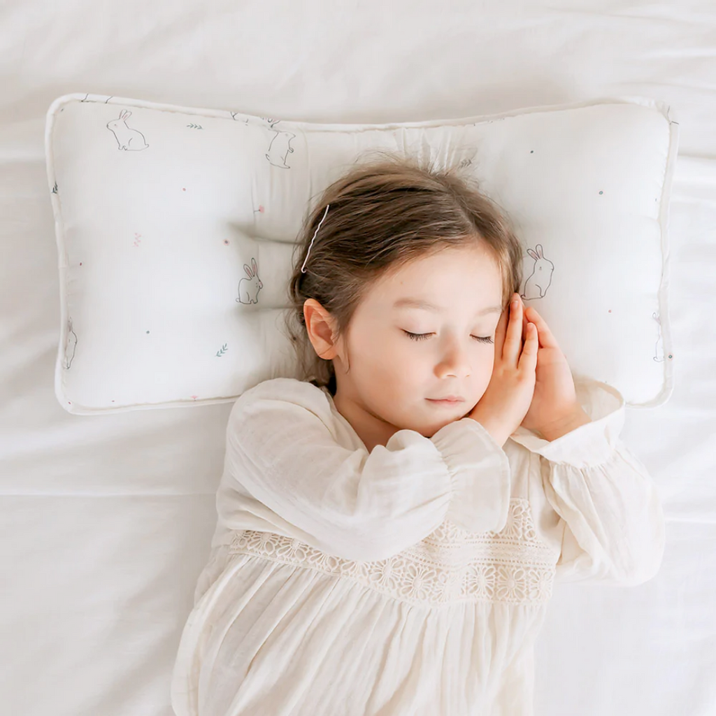 A toddler sleeping comfortably on a bed