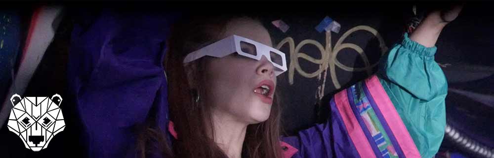 A girl holding her arms up in the air shouting whilst wearing Paper Diffraction Glasses from The Rave Cave