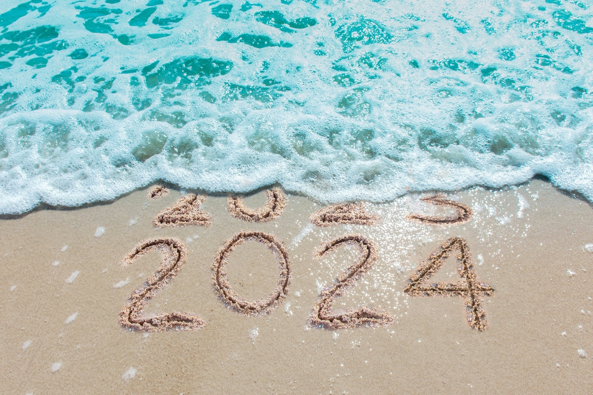 2023 written on the beach in sand being washed away