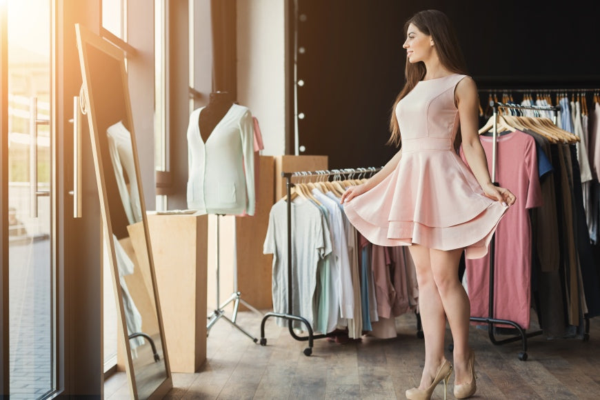 Happy-woman-trying-on-new-dress-in-showroom_-Fashion-and-choice-concept