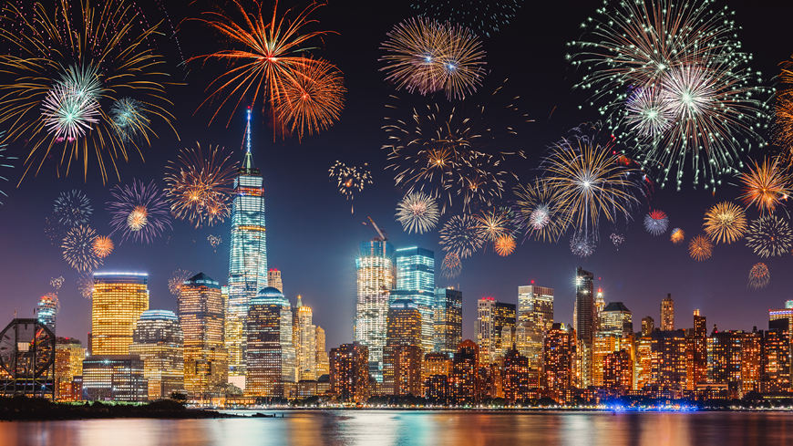 New-Years-Eve-with-colorful-Fireworks-over-New-York-City-skyline-long-exposure-with-dark-blue-purple-sky-orange-city-light-glow-and-reflections-in-the-river