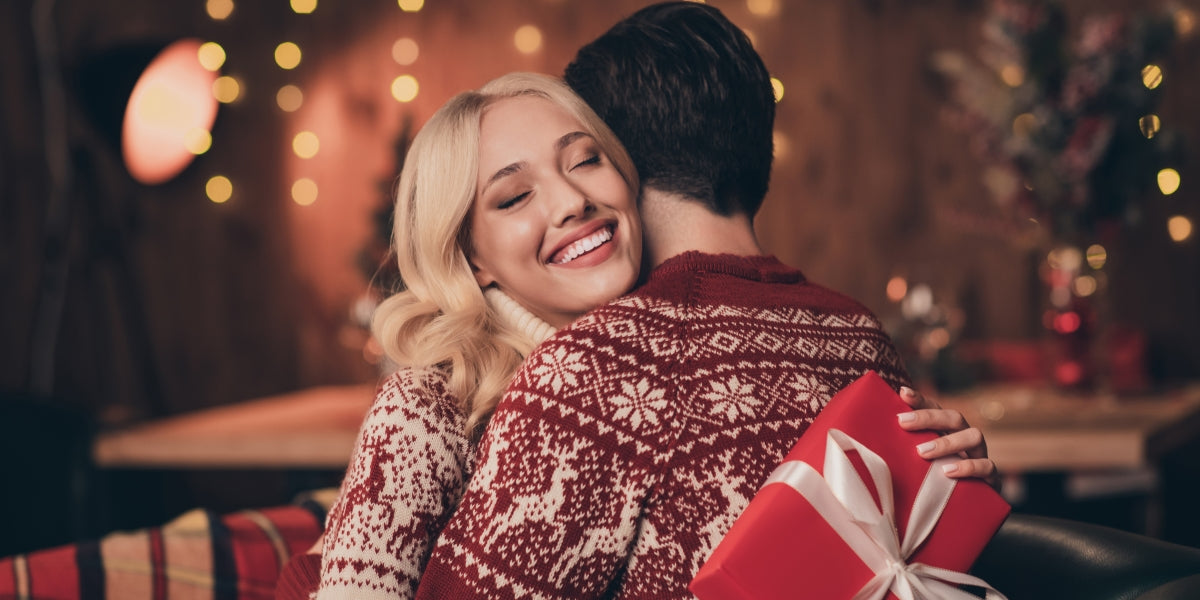 Photo of excited adorable wife husband dressed print pullovers getting christmas gift smiling indoors room home house