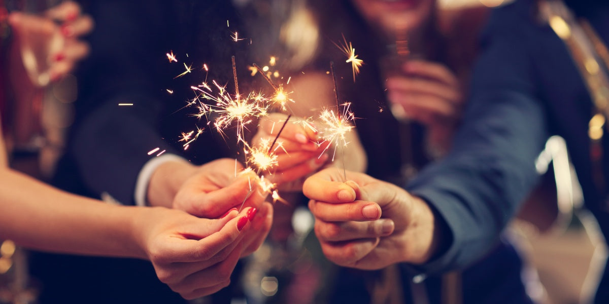 Picture shows a group of friends having fun playing with sparklers