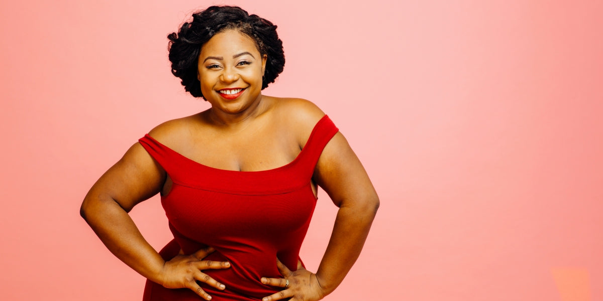 Portrait of happy confident plus size model wearing red dress, smiling