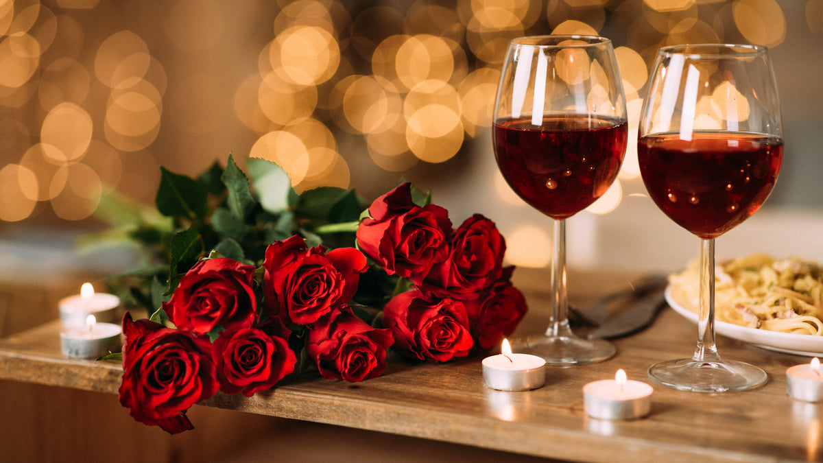 Roses, red wine, and candles at the dinner table