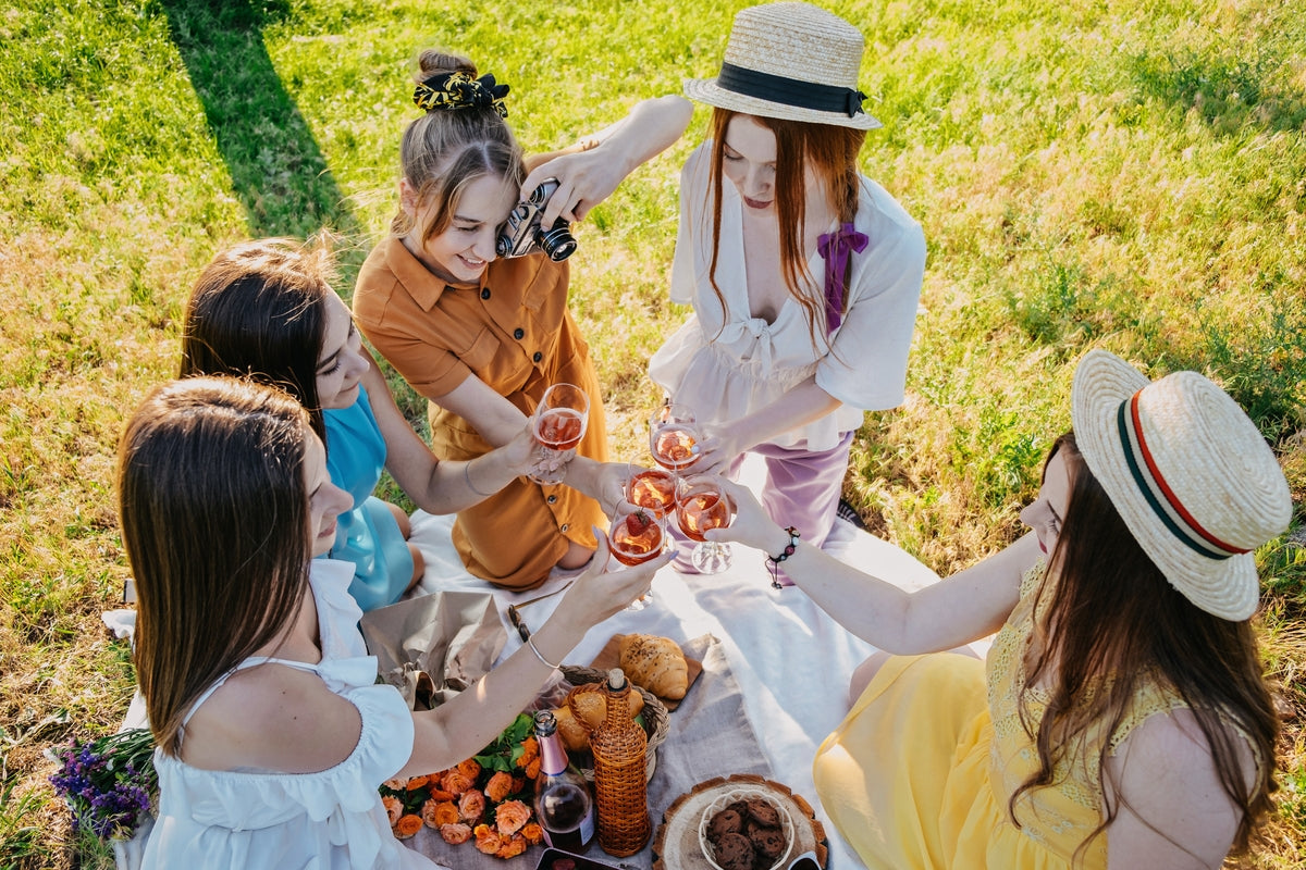 Women enjoying wine on a picnic together