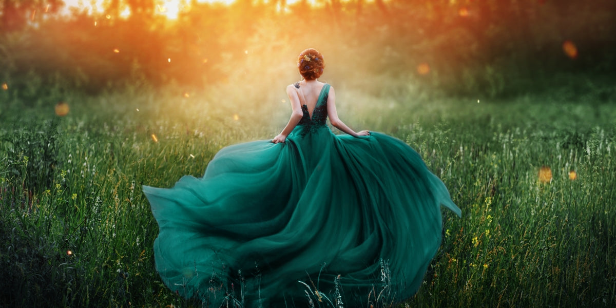 Young beauty woman queen red hair running dark mysterious forest lady long elegant royal emerald dress flying train spring tree grass sunset art photo bare open back no face turned away clothes clothing