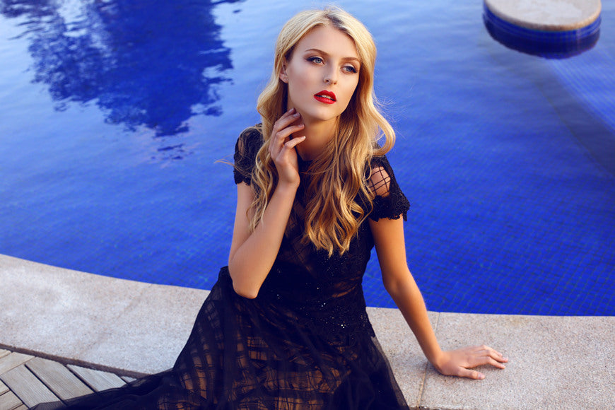 fashion-outdoor-photo-of-beautiful-girl-with-blond-curly-hair-in-elegant-lace-dress-posing-beside-a-swimming-pool