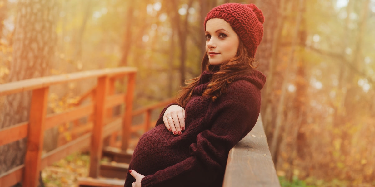 young beautiful pregnant woman in warm knitted marsala outfit on cozy autumn walk, outdoor lifestyle