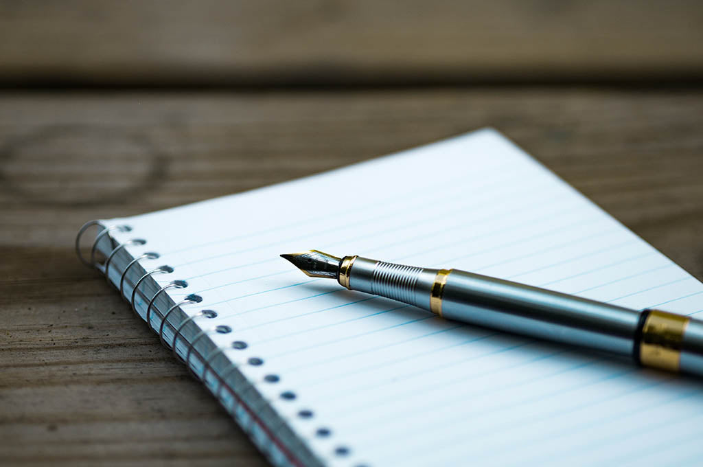 Writing pad and pen - Photo by Aaron Burden on Unsplash