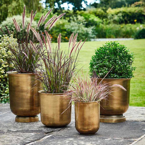 Brass plant pots in assorted sizes on outdoor patio