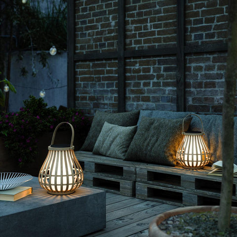 Bamboo LED lanterns on a table and bench outside