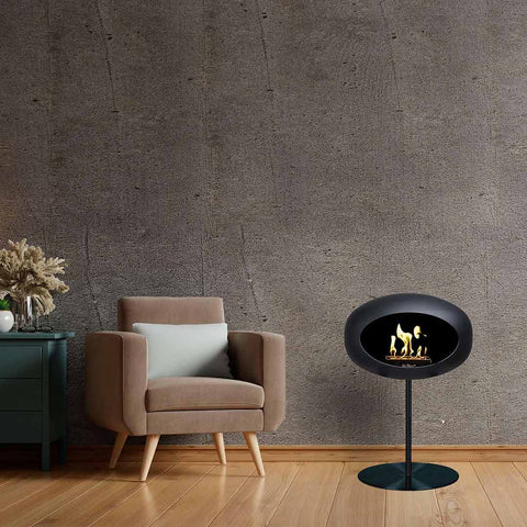 black free standing bioethanol fire place beside an armchair