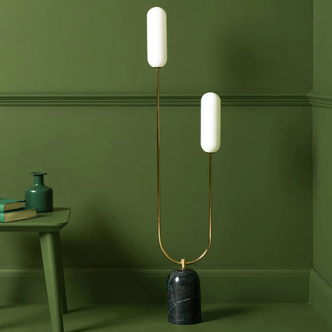 Ourved floor lamp set against olive green wall